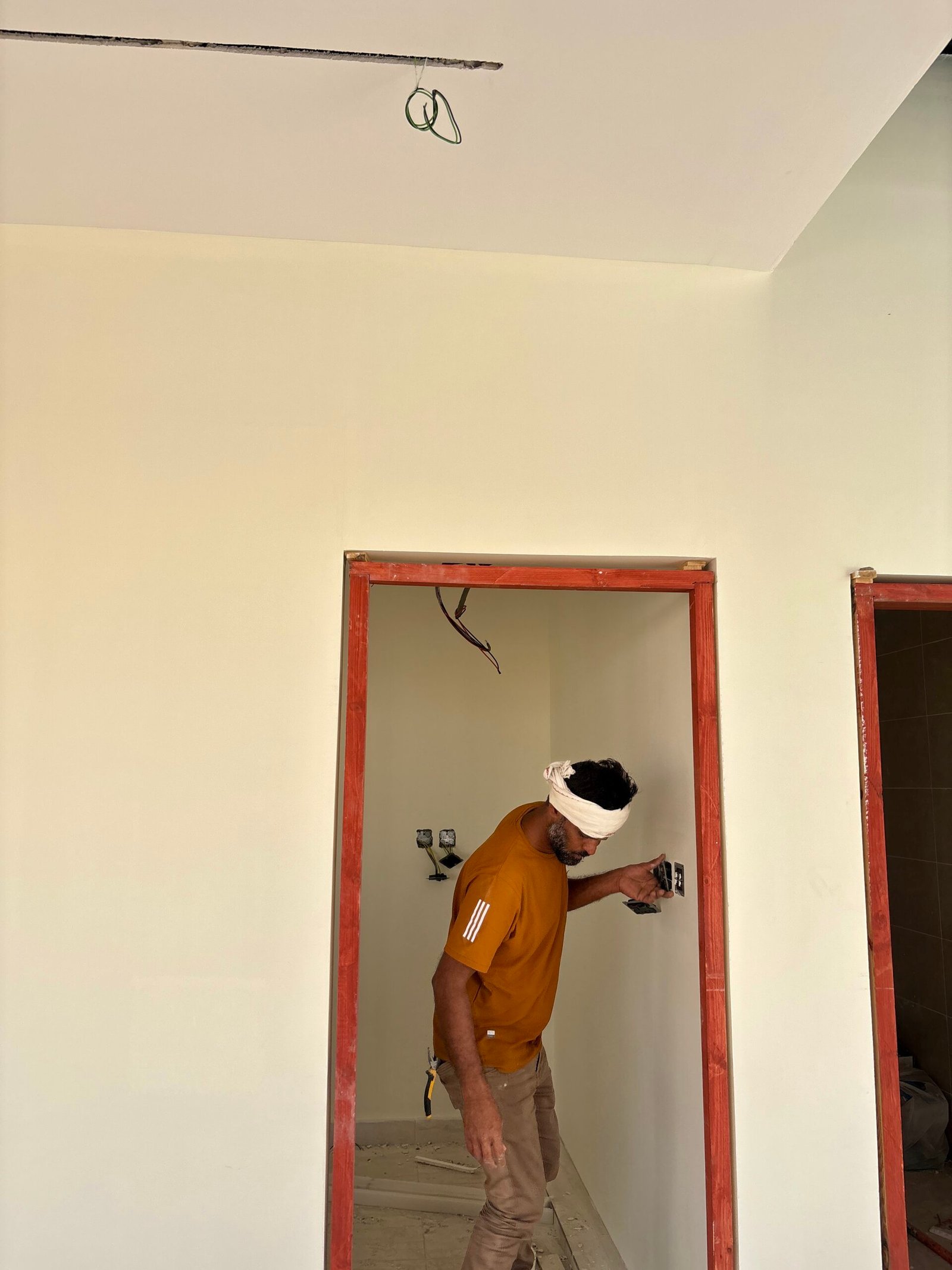 فني داخل مبنى سكني ينفذ أعمال كهرباء ضمن تجهيزات السلامة والاستعداد للطوارئ في المباني