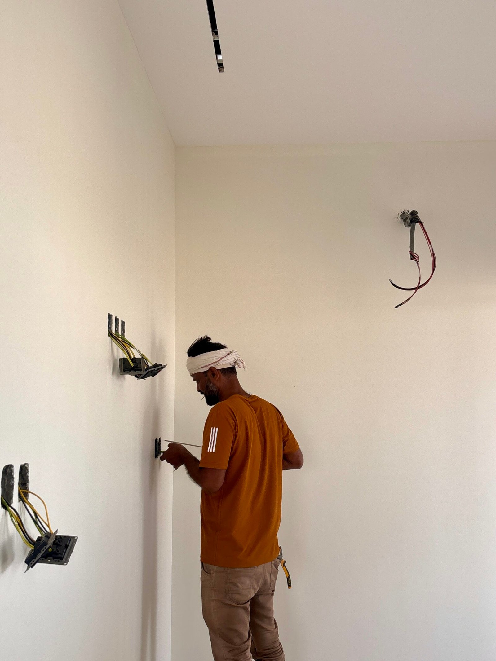 فني كهرباء داخل غرفة بالمبنى يتابع نقاط المفاتيح والتوصيلات ضمن تجهيزات خطة الطوارئ للمباني