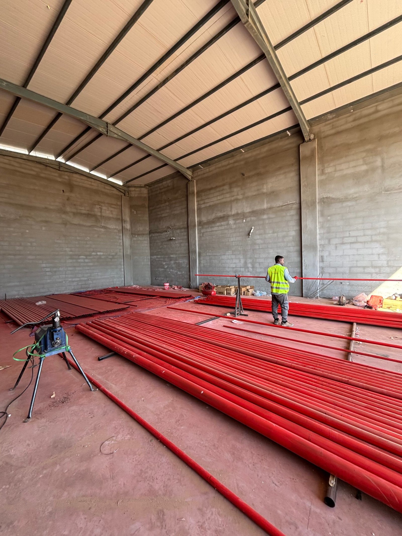 غرفة تحت التشطيب مع تمديدات كهربائية ظاهرة في السقف قبل تركيب وحدات الإنارة