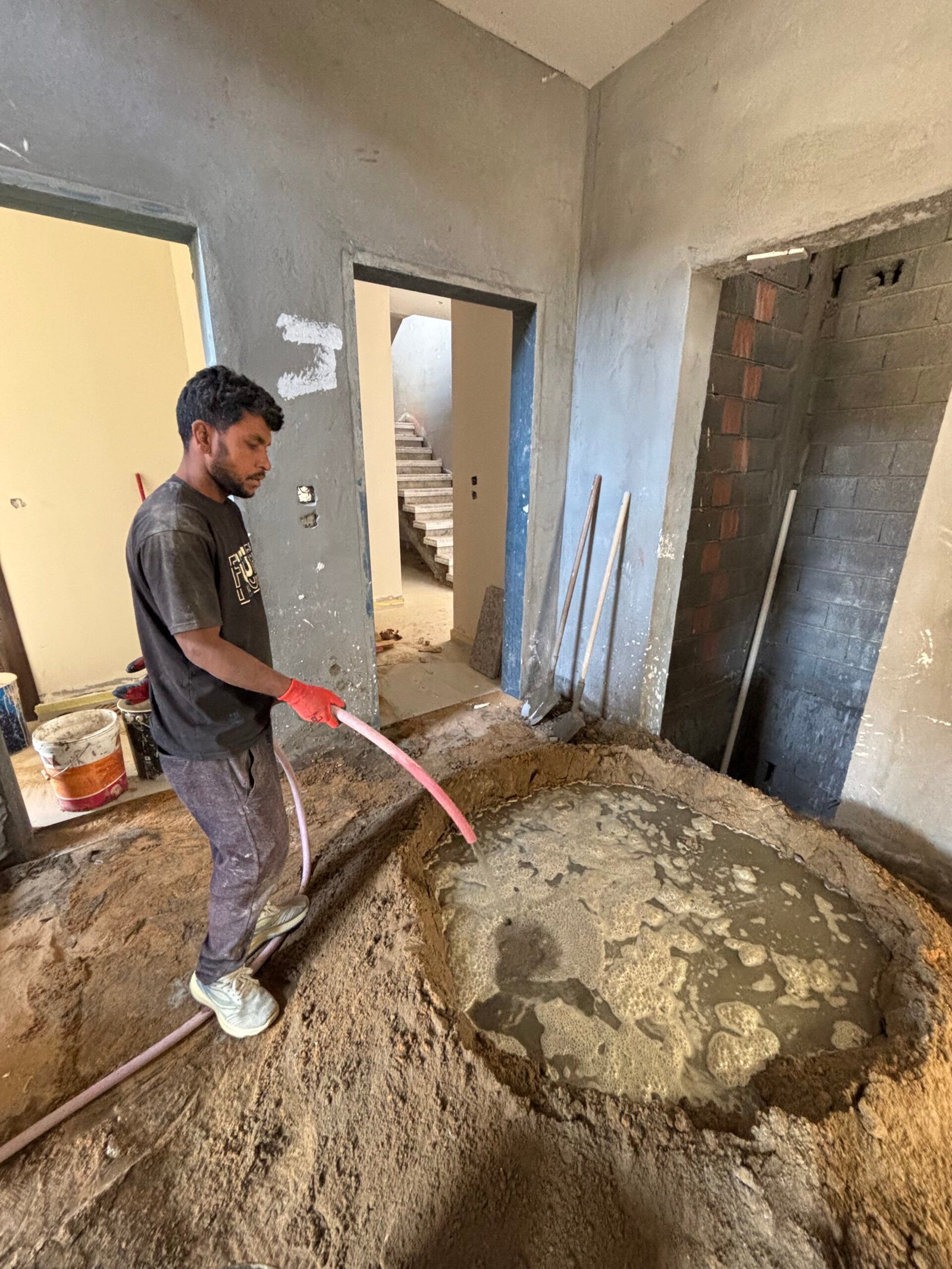 عامل يجري اختبارًا لشبكة السباكة داخل المنزل خلال مرحلة التشطيب وقبل الإغلاق النهائي