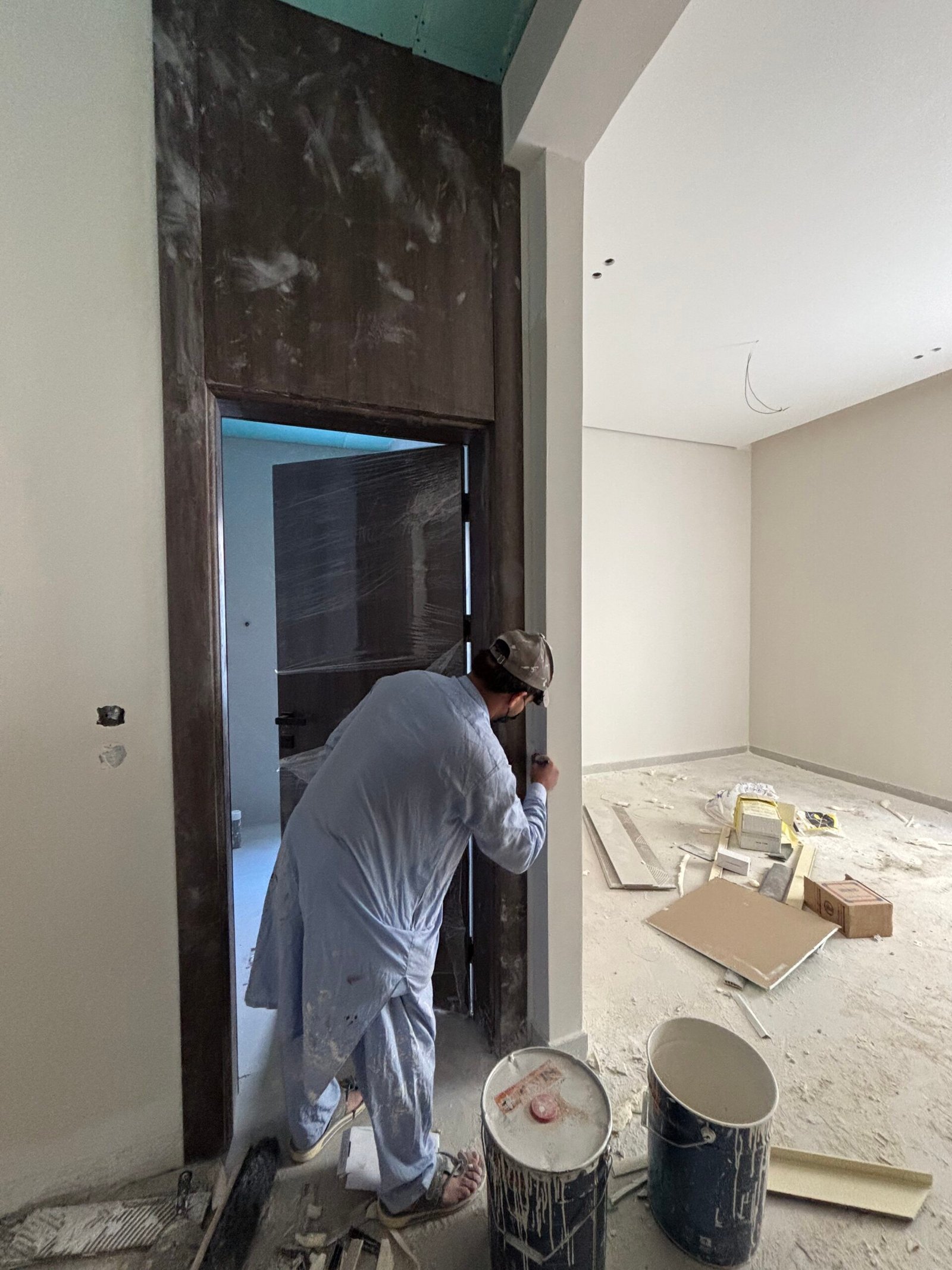 فني يعمل على تشطيب كهرباء المنزل أثناء مرحلة التشطيبات الداخلية