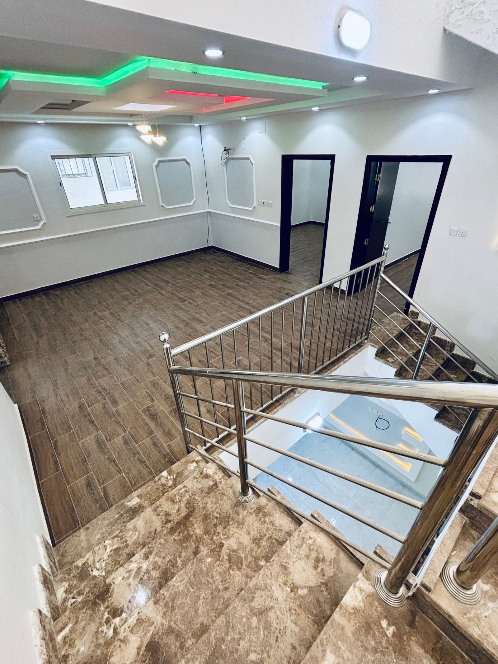 أفضل أنواع الأرضيات في تبوك صالة بتشطيب نهائي وأرضية خشبية/باركيه في تبوك توضح جمال الأرضيات بعد التنفيذ